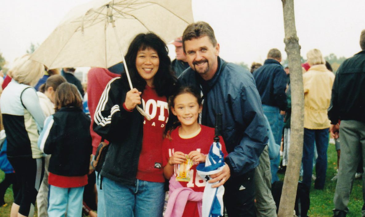 Lifestyle old childhood photograph of parents and their daughter at a track meet
