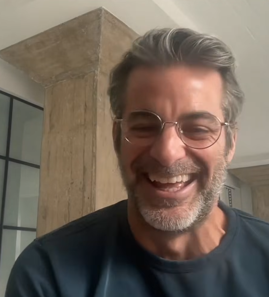 Jim Curtis smiling broadly and laughing while wearing glasses.