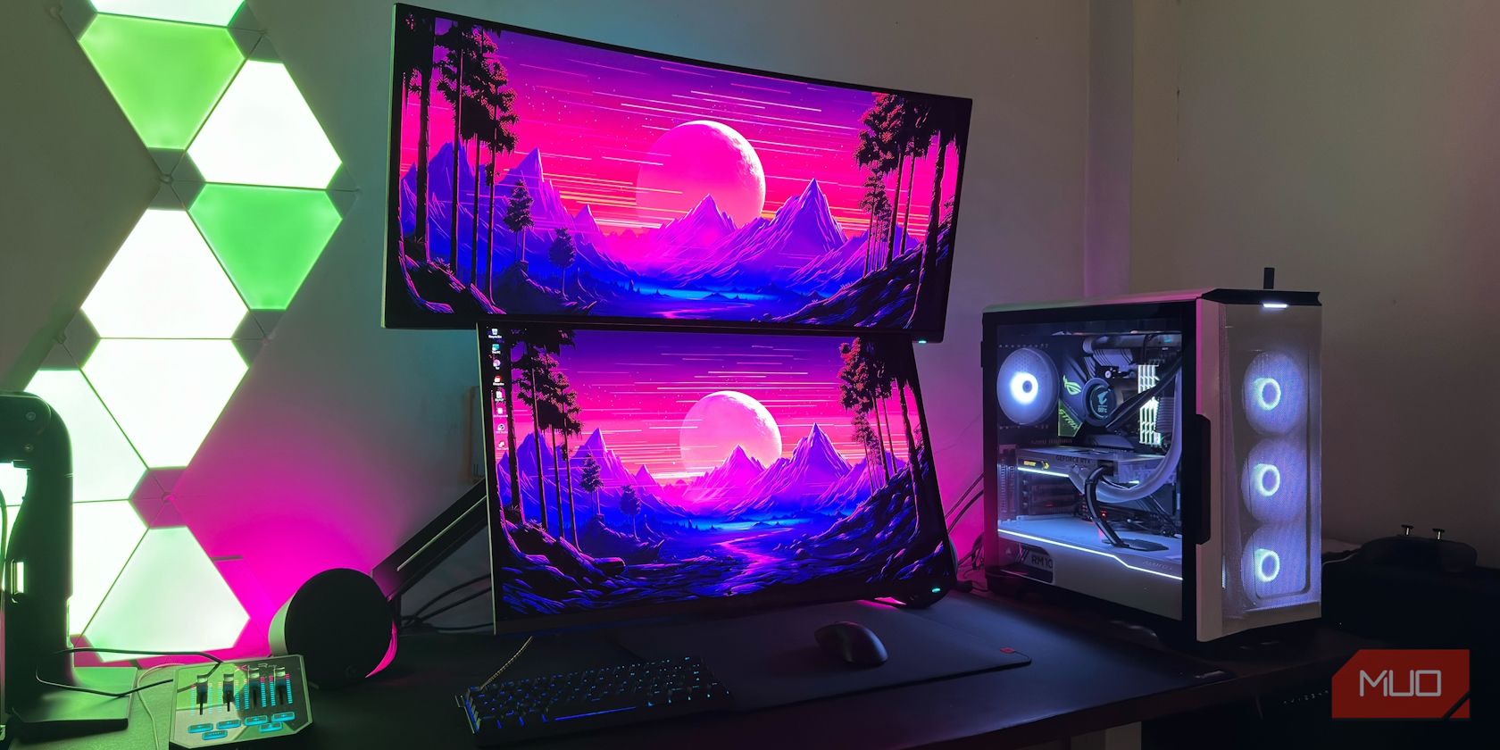 Two OLED monitors VESA mounted on a desk with keyboard and mouse below it